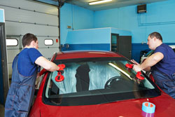 men replacing windshield